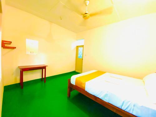 阿鲁甘湾Marina Way Beach Hotel Surf & Tour的一间设有床铺和桌子的房间