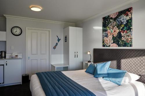 a bedroom with a large bed with blue pillows at Bendamere House Bed & Breakfast in Kaikoura