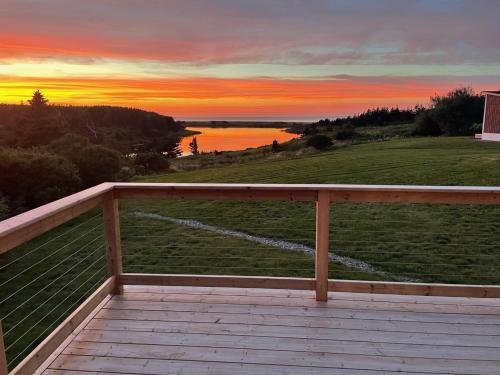 a view from the deck of a house at sunset at Colindale Beach Villas -- MIni Villas in Port Hood