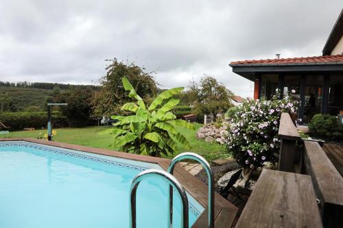 une piscine dans une cour à côté d'une maison dans l'établissement La Bergerie, à Frémifontaine