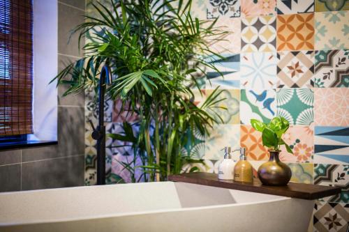 a bathroom with a bath tub with a plant at Hoi An Clara House in Hoi An