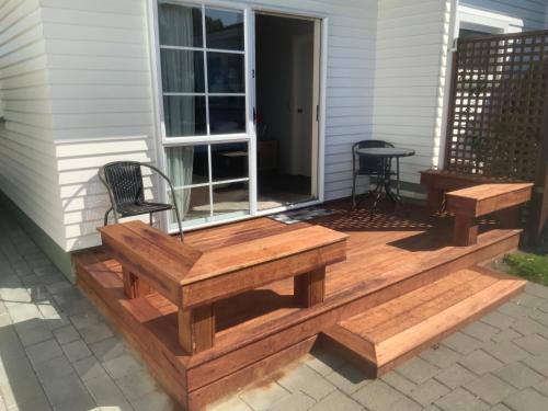 a wooden deck with a bench and a table at Bendamere House Bed & Breakfast in Kaikoura