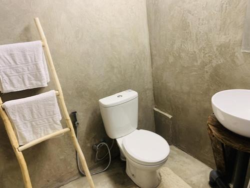 a bathroom with a white toilet and a sink at Enchanted Villa in Kandy