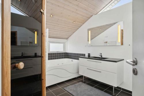 a white bathroom with a tub and a sink and a bath tub at Lovely Summer House In Haderslev in Haderslev