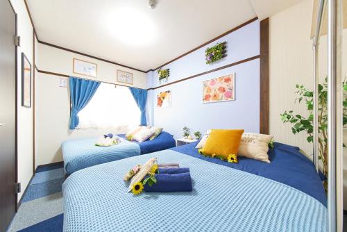 two beds in a room with blue sheets at Belmont 101 3min to Station Easy Access Ueno Asakusa Skytree Sleeps 5 in Tokyo