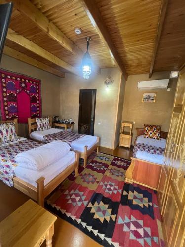 a room with two beds and a rug at Old Palace Hotel in Samarkand