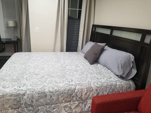 a bedroom with a bed and a red chair at Beautiful New 4 Bedroom 3 Bath Family Home Or 1 BR Apt Nr Howard U Downtown NW DC in Washington