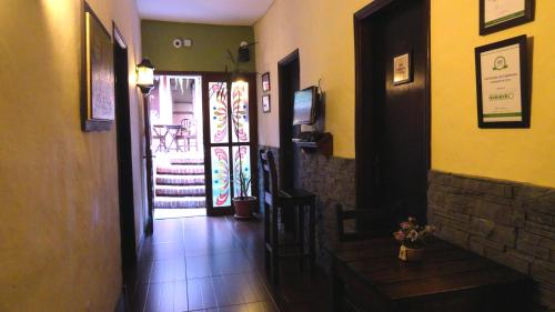 a hallway leading to a room with a door and a staircase at Hotel Rivera in Colonia del Sacramento
