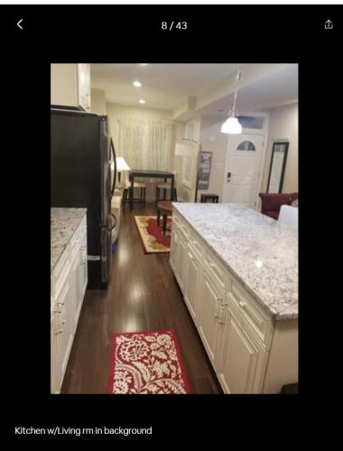 a kitchen with a black refrigerator and a counter top at Beautiful New 4 Bedroom 3 Bath Family Home Or 1 BR Apt Nr Howard U Downtown NW DC in Washington, D.C.