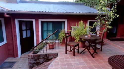 a patio with a table and chairs and a house at Hotel Rivera in Colonia del Sacramento
