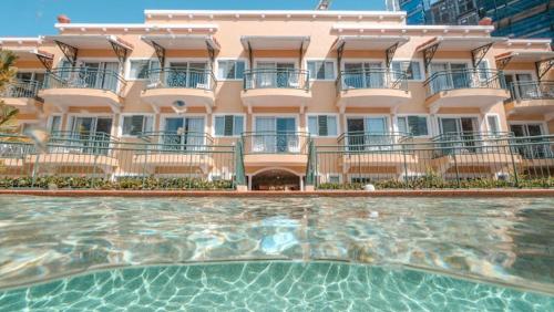 a large building with a swimming pool in front of it at Stylish CBD retreat - 8 Il Palazzo in Cairns