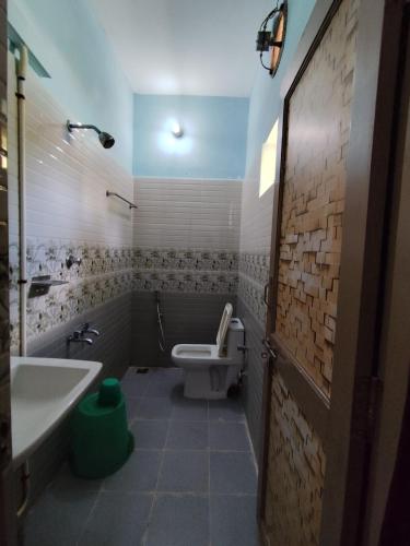 a bathroom with a toilet and a sink at Sri Murugan Beach Paradise Hotel in Mahabalipuram