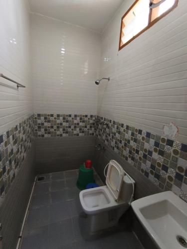 a bathroom with a toilet and a sink at Sri Murugan Beach Paradise Hotel in Mahabalipuram