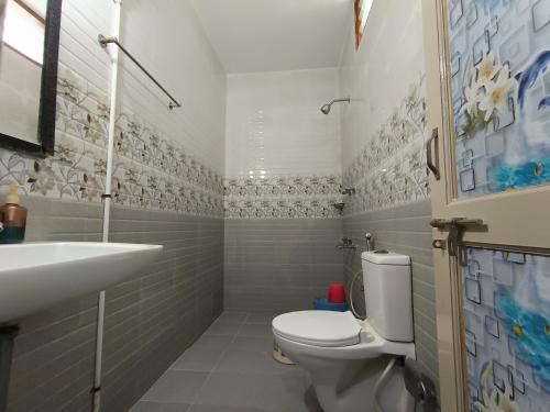 a bathroom with a toilet and a sink at Sri Murugan Beach Paradise Hotel in Mahabalipuram
