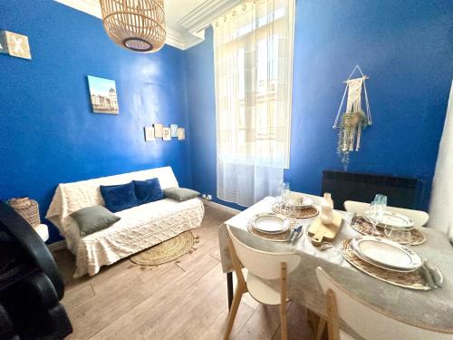 - un salon bleu avec une table et un canapé dans l'établissement Appart l'Echappée Belle, Centre Historique, Gare, à Montpellier