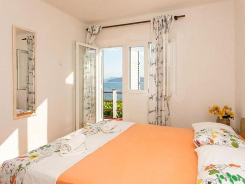 ein Schlafzimmer mit einem Bett und einem großen Fenster in der Unterkunft Apartments Stipo - Comfort Two Bedroom Apartment with Balcony and Sea View A2 in Drače