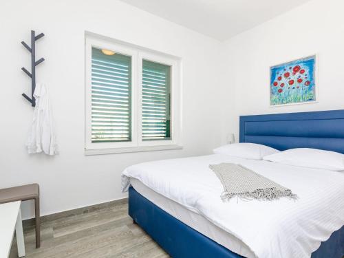 Un dormitorio con una cama azul y una ventana. en Apartments Villa Lukas - ''No 1'' One-Bedroom Apartment with Balcony and Sea View, en Cavtat