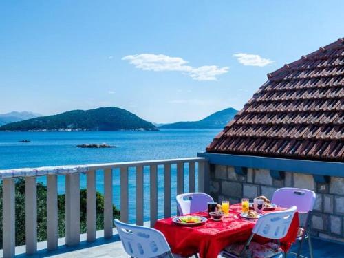 a table and chairs on a balcony with the ocean at Apartment Tonka's Terrace - Studio Apartment with Terrace and Sea View in Suđurađ