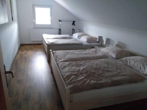 three beds in a room with a window at Holiday Home Gra ec - Three Bedroom Holiday Home with swimming pool in Zagreb