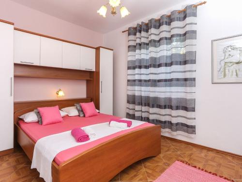 ein Schlafzimmer mit einem großen Bett mit rosa Kissen in der Unterkunft Apartments Lina - Two Bedroom Apartment with Terrace A1 in Brsečine