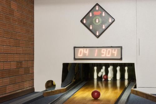 a bowling alley with balls on the lanes and a clock at Hotel & Gasthaus Nagel GmbH in Südlohn