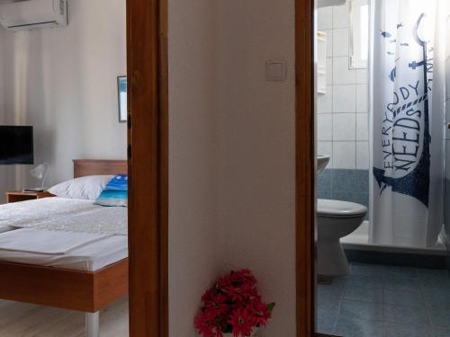 a bedroom with a bed and a bathroom with a toilet at Apartments Belenum - One-Bedroom Apartment with Balcony and Sea View no 3 in Mlini