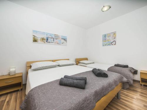 zwei Einzelbetten in einem Schlafzimmer mit Holzboden in der Unterkunft Villa Dvori Vi kovi-Seven Bedroom Villa with Swimming Pool in Podstrana