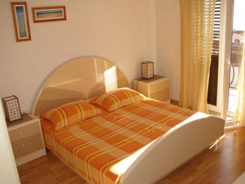 a bedroom with a bed with an orange and yellow blanket at Apartment in Bol with balcony in Bol
