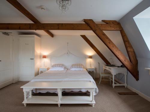 a bedroom with a white bed and a desk at B & B Hotel The Baron Crown in Den Helder