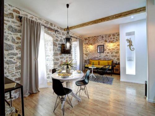 a living room with a table and chairs at History House Moja Ti 1830 - Deluxe Apartment Gorica in Senj