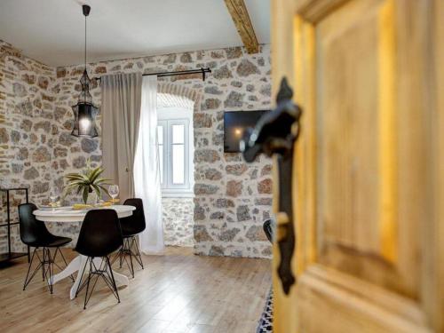 a living room with a table and chairs in a room at History House Moja Ti 1830 - Deluxe Apartment Gorica in Senj