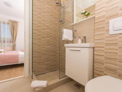 a bathroom with a shower and a toilet and a sink at Villa LA-Comfort One Bedroom Apartment with Sea View Terrace 1 in Veliki Drvenik