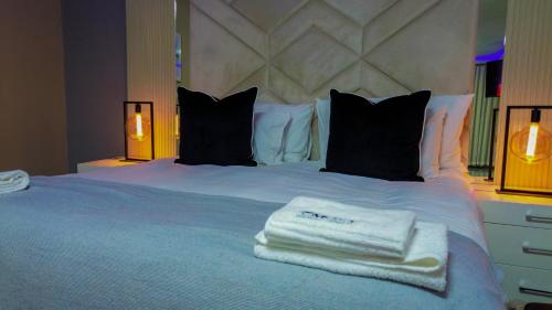 a bedroom with a white bed with two towels on it at Mercy Boutique Hotel in Thohoyandou