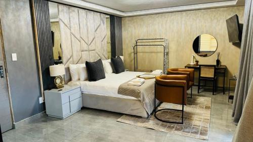 a bedroom with a bed and a desk and a chair at Mercy Boutique Hotel in Thohoyandou