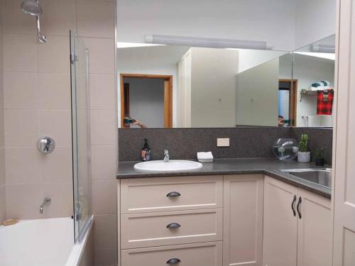 ein Badezimmer mit Waschbecken, Dusche und Spiegel in der Unterkunft Alba the Scots Cottage walk every where in Maleny