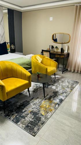 a bedroom with two yellow chairs and a bed at Mercy Boutique Hotel in Thohoyandou