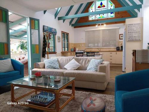 a living room with a couch and a table at Alba the Scots Cottage walk every where in Maleny
