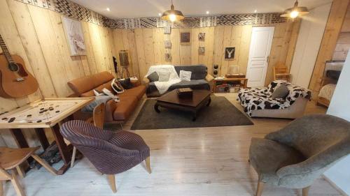 a living room filled with furniture and a guitar at Yourtes Olachat proche Annecy in Faverges