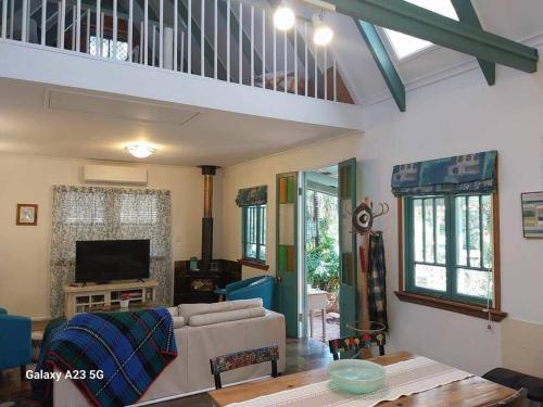 a living room with a couch and a table at Alba the Scots Cottage walk every where in Maleny