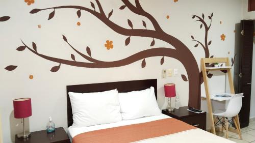 een slaapkamer met een muurschildering van bomen aan de muur bij Terraza Studios in Cabo San Lucas