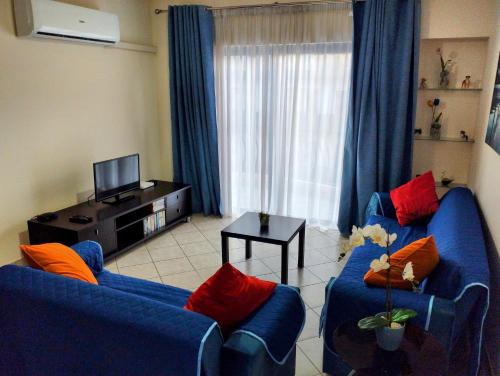 a living room with two blue couches and a television at Perfect tourist accommodation in Bugibba square! in St Paul's Bay
