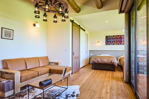 a living room with a couch and a bed at El Patio Ranch in Aso