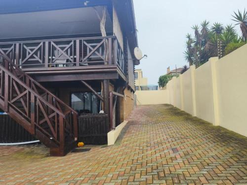 a brick walkway next to a building with a balcony at Boitumelo Bluewater Apartments in Port Elizabeth