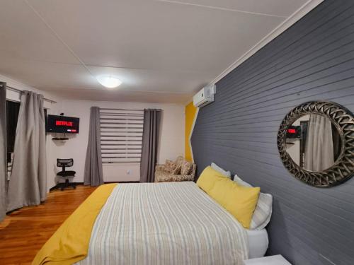 a bedroom with a bed and a mirror on the wall at Boitumelo Bluewater Apartments in Port Elizabeth