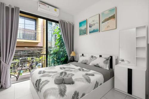 ein Schlafzimmer mit einem Bett und einem großen Fenster in der Unterkunft Enjoy Samui Residence in Bangrak Beach