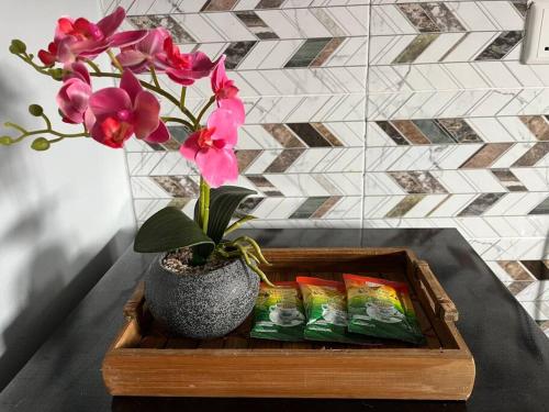 a wooden tray with a vase with flowers and packets of tea at JJ Homestay Terengganu in Marang
