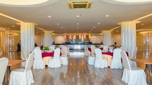 a banquet hall with white tables and white chairs at Ululani Bali in Uluwatu