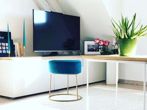 - un bureau avec un ordinateur et une chaise bleue dans l'établissement Appartement cosy à 10min à pieds du centre-ville, à Colmar