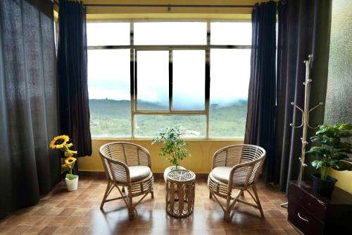 a room with three chairs and a table and a window at Vaga Hills Resort by Red Rabbit in Vagamon