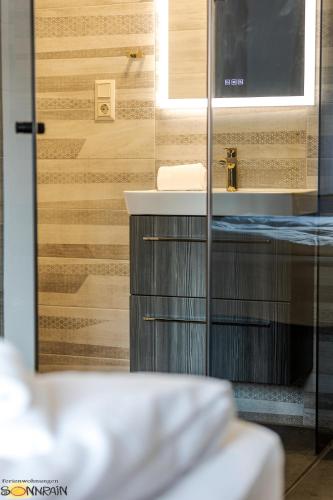 a bathroom with a sink and a mirror at Sonnrain GmbH Apartment Sonnberg 77 Leogang in Leogang